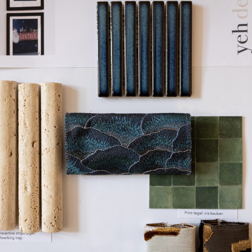 Yeh Design material mood board with navy glaze tile, travertine strips, teal embroidered fabric swatch, and sage green ceramic tiles